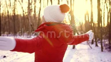 在户外享受冬日的女人。快乐的女孩慢慢地举起手臂，旋转着